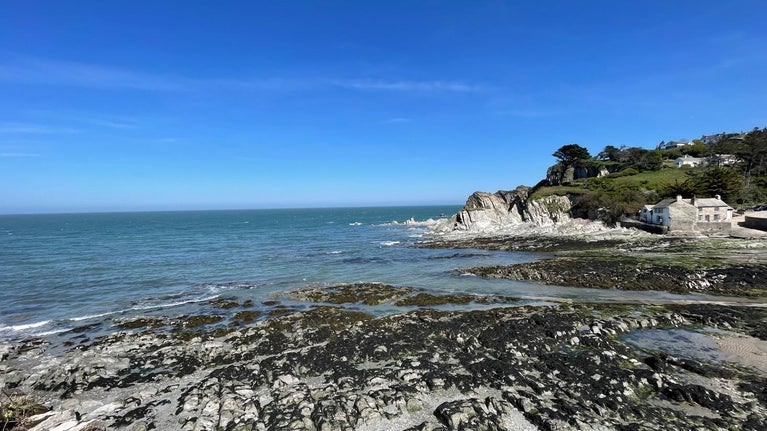 Over looking a bay with a low tide and exposed rockpools on the beach
